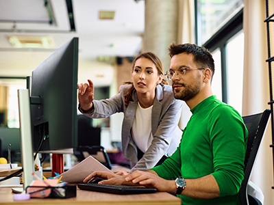 Dame und Herr im Büro vor Computer